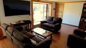 sala de estar con 2 sofás y TV de pantalla plana en Hospedaje Las Animas Valdivia en Valdivia