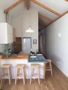 a kitchen with a counter with stools and a sink at Casa da Papanata in Viana do Castelo