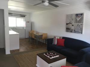 uma sala de estar com um sofá e uma mesa em Tomaree Lodge em Nelson Bay