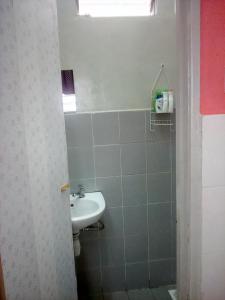 a bathroom with a sink and a mirror and a window at Kak Chik Homestay Kepala Batas in Kepala Batas