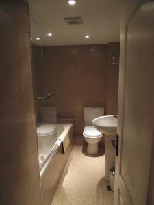 a bathroom with a toilet and a tub and a sink at Carpenters Cottages in Llanishen