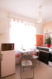 cocina con mesa, mesa pequeña y sillas en Park Apartment, en Ventspils