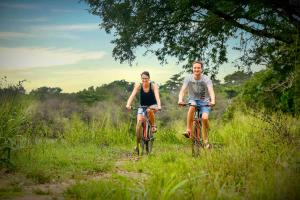 a man and a woman riding bikes down a trail at Elephas Resort & Spa in Sigiriya