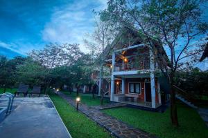 a house with a balcony on the side of it at Elephas Resort & Spa in Sigiriya