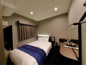 a small bedroom with a bed and a television at Act Hotel Roppongi in Tokyo