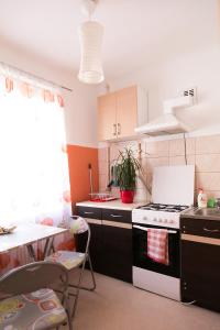 eine Küche mit einem schwarzen und weißen Herd und einem Tisch in der Unterkunft Park Apartment in Ventspils