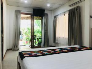 a bedroom with a bed and a large window at Ananda Resort in Mui Ne