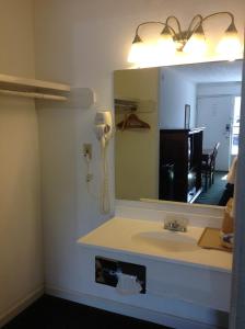 W łazience znajduje się umywalka i lustro. w obiekcie Houston Inn and Suites w mieście Houston