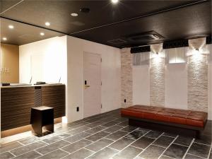 a lobby with a brown leather couch in a room at Act Hotel Roppongi in Tokyo