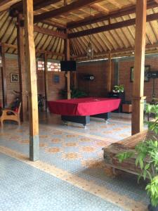 a large pool table in a pavilion with a red cloth at Kayu Tua Villa in Uluwatu