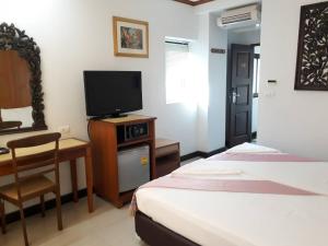 una camera d'albergo con 2 letti, una scrivania e una TV di New Siam II - SHA Certified a Bangkok