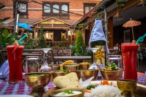 a table topped with food and a bottle of wine at Apsara Boutique Hotel in Kathmandu