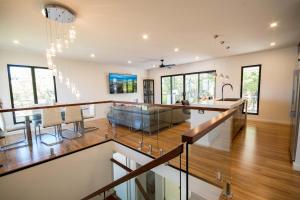 uma sala de jantar e sala de estar com uma mesa de jantar numa casa em Beautiful Modern Luxury em Townsville