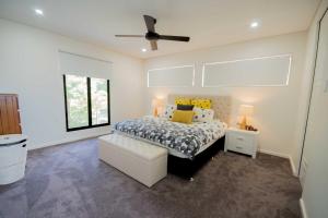 a bedroom with a bed and a ceiling fan at Beautiful Modern Luxury in Townsville