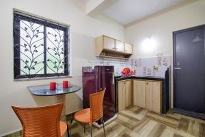 a kitchen with a small table and a refrigerator at Palm Shades Spring in Benaulim