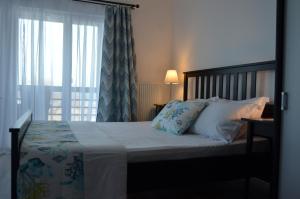 a bedroom with a large bed with a window at California Dreaming in Mamaia Sat/Năvodari