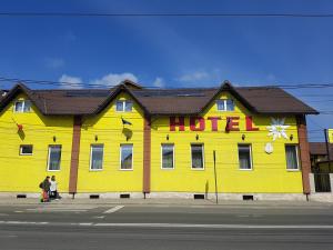a yellow building with a hotel sign on it at Hotel Edelweiss in Mediaş
