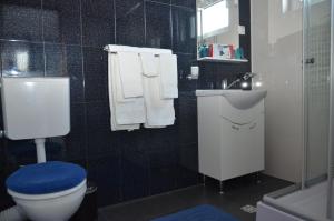 a bathroom with a toilet and a sink with towels at California Dreaming in Mamaia Sat/Năvodari