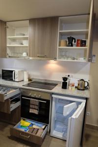 eine Küche mit einem offenen Kühlschrank und einem Herd in der Unterkunft Apartaments Sant Miquel in Sant Joan de les Abadesses