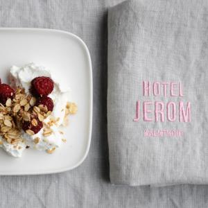 a bowl of yogurt and berries next to a book at Hotel Jerom in Kalmthout