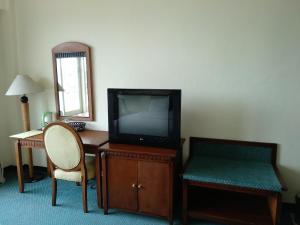 a room with a tv and a desk and a chair at Top Star Hotel in Cepu