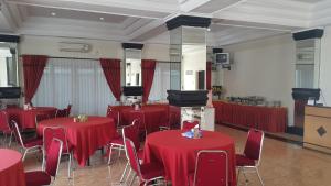 una habitación con mesas y sillas con mesas rojas y sillón en Top Star Hotel, en Cepu