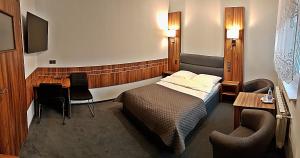 een slaapkamer met een bed en een tafel en stoelen bij Hotel Hawana in Bydgoszcz