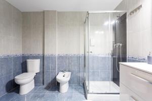 a bathroom with a toilet and a shower at 1- Apartamento Playa Canido in Malpica +12 photos