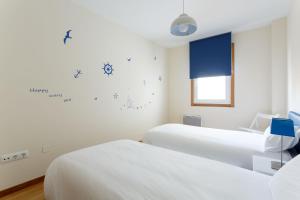 マルピカにある1- Apartamento Playa Canidoの白い壁の病室で、ベッド2台が備わります。