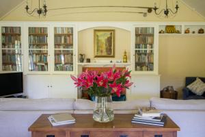 a living room with a vase of pink flowers on a table at Coldstream Estate - The Whare in Coldstream