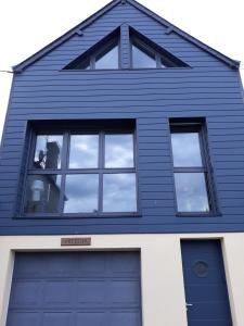 グランカン・メジーにあるL atelierの青いガレージドア付きブルーハウス