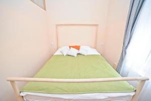 ソポトにあるSand Apartment by Grand Apartmentsの小さなベッドルーム(緑の毛布付きのベッド付)
