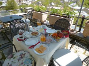 un tavolo con prodotti per la colazione su un balcone di Nymfes Hotel a Nymfaio