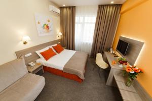 アナパにあるMandarin Hotelのベッドとソファ付きのホテルルーム