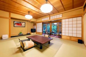 a japanese room with a table and chairs in it at Arashiyama Benkei in Kyoto