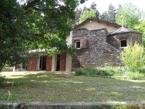 una vieja casa de piedra en un patio en L'Oursiere en Bédouès
