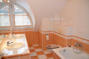 a bathroom with two sinks and a tub and a toilet at Ferienwohnung Fischerhafen 14/Guent in Ostseebad Karlshagen
