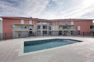 un edificio con una piscina di fronte a un edificio di Cote d'Azur Vence a Vence