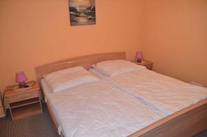 a bed in a bedroom with two nightstands and two lamps at Ferienwohnung Fischerhafen 14/Guent in Ostseebad Karlshagen