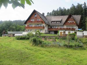 una casa grande en la cima de un campo verde en Haus Erlenmoos, en St. Georgen im Schwarzwald