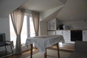 a white kitchen with a table and a window at Paradise Corner in Pomorie