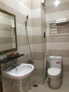 ein Badezimmer mit einem Waschbecken, einem WC und einem Spiegel in der Unterkunft Ha Anh Hotel in Cao Lãnh