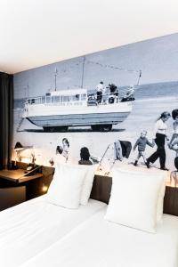 ein Schlafzimmer mit einem Wandbild eines Bootes am Strand in der Unterkunft Hotel Albert Plage in Knokke-Heist