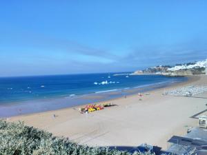 a beach with umbrellas and the ocean at Albufeira Beach Hotel by Kavia in Albufeira
