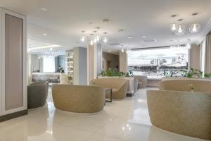 a lobby with chairs and a table and a kitchen at Hotel Pokrovsky in Pskov