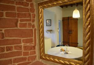 - un miroir dans une chambre avec une table en face d'un mur de briques dans l'établissement Calzaiuoli luxury and characteristic apartment, à Florence