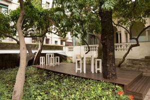 a wooden deck with white chairs and trees at Petit Palace Boqueria Garden in Barcelona