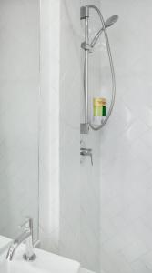a shower in a bathroom with a sink at Konko Hostel Jakarta in Jakarta