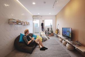 a woman sitting on a couch in a living room at Konko Hostel Jakarta in Jakarta +36 photos