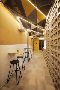 a cafeteria with tables and stools in a room at Konko Hostel Jakarta in Jakarta